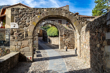 Naklejka premium Historic stone arches and cobblestone streets in the old town of Potes, Cantabria. Spain