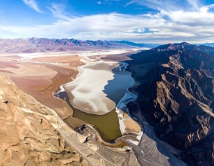 High-altitude view of a colorful, arid landscape with a valley and mountain range