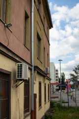 Building exterior with air conditioning units and cloudy sky in urban setting during daytime