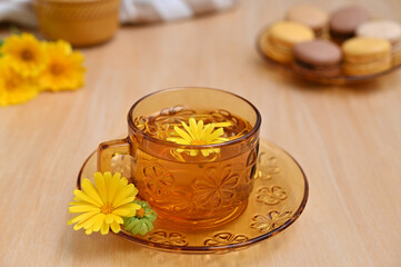 a warming drink of calendula flowers in a yellow cup on the table