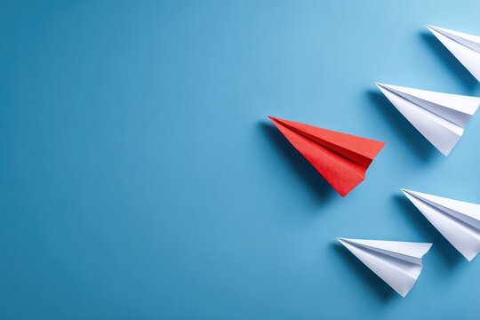 Creative approach to business innovation illustrated by a group of paper airplanes in distinct colors flying in different directions against a blue background