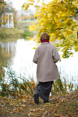 Girl in Autumn Park in Coat and Red Scarf
