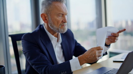 Senior financier hands typing laptop closeup. Businessman checking papers data 