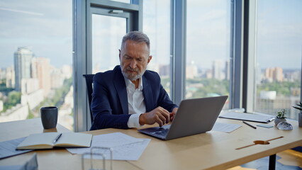 Busy analyst working computer looking papers at corporate workspace closeup. 