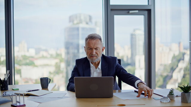 Stressed businessman reviewing documents at office closeup. Worried senior man - Powered by Adobe