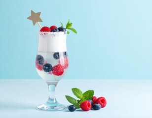 Refreshing berry drink features fresh blueberries and raspberries with mint and a star stirrer on a light blue background.