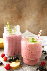 Refreshing mixed berry and banana smoothie with mint garnish. Copy space.