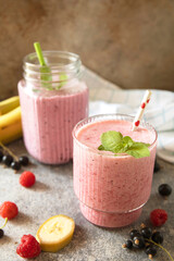 Refreshing mixed berry and banana smoothie with mint garnish.