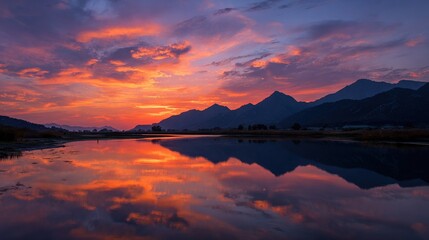 Fototapeta premium A vast expanse of water with towering mountains reflected in the sky above, all bathed in a cloudy reflection below