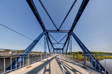 Bolts and nuts on metal plates of steel structure of heavy duty straight crossbar of frame and bridge support