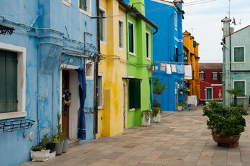 Italian postcard, picturesque street scene in Burano, showcasing its iconic colorful facades. Evokes wanderlust and timeless beauty.