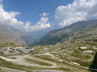 Scenic mountain view from Lago Serr&ugrave;, located in the Gran Paradiso National Park in the Italian Alps. The image captures a winding alpine road