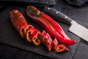 Corno di Toro Rosso pepper. Red paprika vegetable on black table.