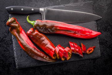 Corno di Toro Rosso pepper. Red paprika vegetable on black table. Top view.