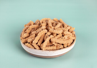 Indian snack murukku made from rice flour and spices on blue background. Indian food.
