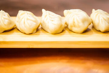 Raw and cooked Japanese gyoza dumplings on rustic surfaces – handmade Asian cuisine