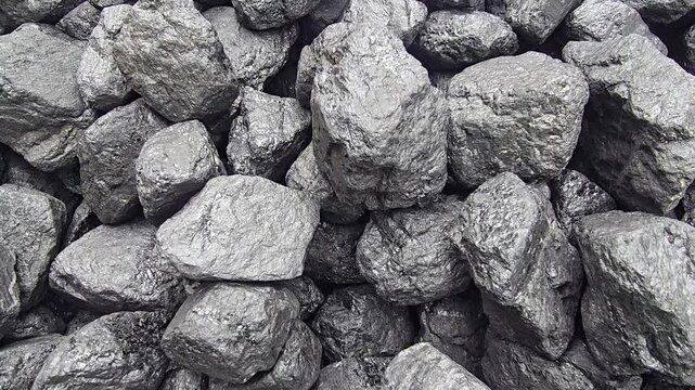A pile of dark, lumpy coal gleams with a slight sheen, showing a rough, varied texture. Video 4k
