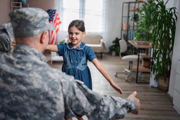 Soldier father embracing daughter at home