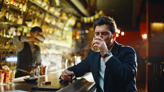 Drunken man smoking cigarette alone bar counter closeup. Depressed guy drinking