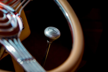 The gear shift lever of a car that is framed by the steering wheel