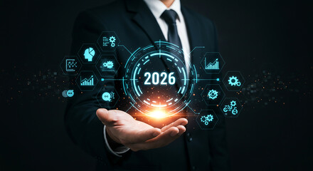 A man presenting a futuristic hologram with the year 2026 and various business related icons around it