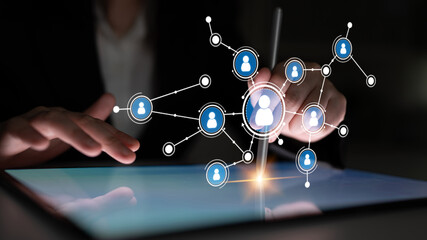 A business professional uses a digital tablet to engage with a user network interface. This image symbolizes modern communication and digital interactions in professional settings. Tessel