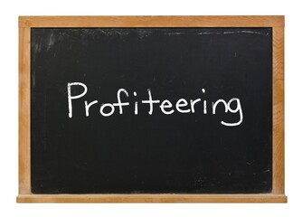 Profiteering written in white chalk on a black chalkboard with a wood frame