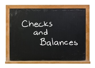 Obraz premium Checks and Balances written in white chalk on a black chalkboard with a wood frame