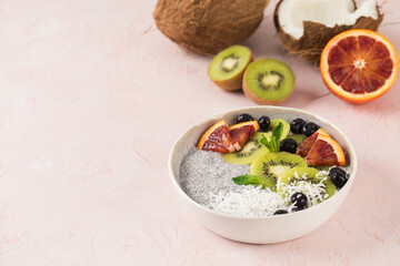 Healthy breakfast bowl with chia pudding on coconut milk, kiwi, blood orange and berries. Copy space