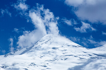 A close-up of a mountain peak in bad weather, leading to the death of climbers in windy weather, snow-capped peaks in the clouds