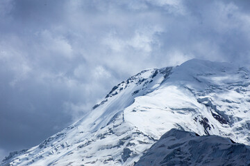 A close-up of a mountain peak in bad weather, leading to the death of climbers in windy weather, snow-capped peaks in the clouds