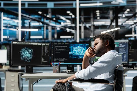 Data center worker with disability in wheelchair using deep learning algorithms to analyze datasets. Person with paraplegia in inclusive server hub using AI to recognize data patterns