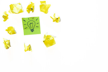 Idea lightbulb sticky note surrounded by crumpled paper