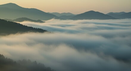 Obraz premium Panoramic view of mountain ranges with a sea of clouds. Natural phenomenon at sunrise or sunset. Beautiful misty landscape for travel and nature.