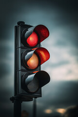 Close-up of a red traffic light against a cloudy sky, with rich colors and visible texture