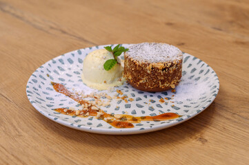 Chocolate lava cake with vanilla ice cream, crushed nuts and powdered sugar, artistically plated on...