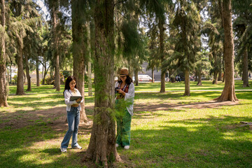 Fototapeta premium Biology students doing fieldwork, studying trees and plants
