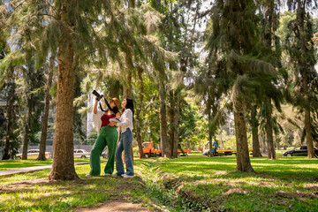 Fototapeta premium Female botanical biology students doing fieldwork in urban park