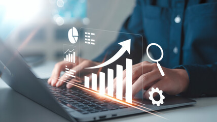 Businessperson analyzing financial growth charts and data on a laptop with digital interface overlay showing upward trends and analytics icons