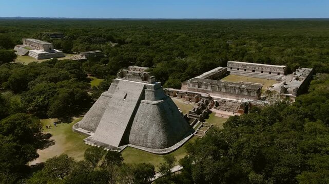 Aerial orbit around Pyramid of the Magician and Nunnery Quadrangle in Mayan ruins of Uxmal