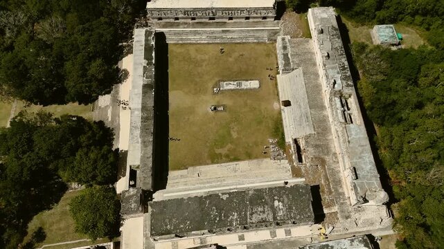 Aerial crane up from Nunnery Quadrangle revealing Mayan ruins and forest in Yucatan