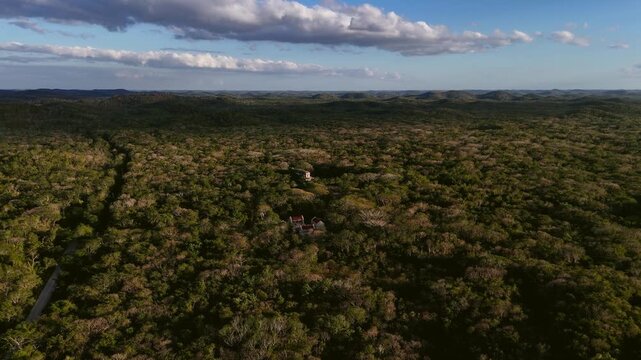 Aerial push in over tropical forest revealing Mayan ruins of Labna in Yucatan