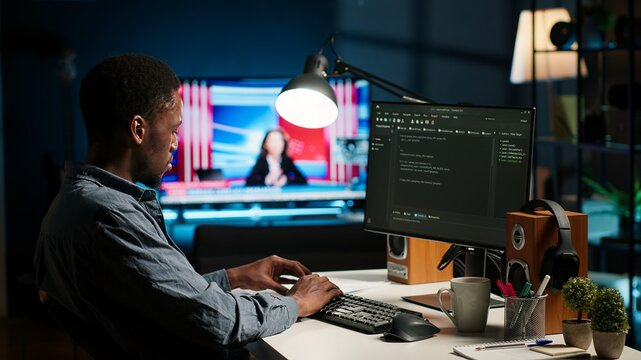 African american man working on PC to write code and programming in artificial intelligence and deep learning. Male IT engineer using pc to ensure cyber security, neural network. Camera B.