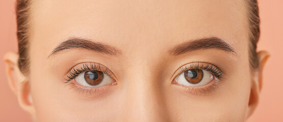 Naklejka premium Young woman with beautiful eyebrows on color background, closeup