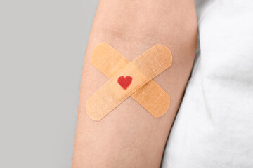Woman with applied medical patches on grey background. World Blood Donor Day