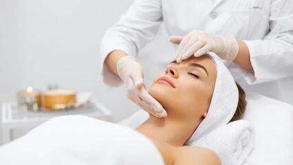 Naklejka premium Young woman enjoying a refreshing facial treatment, rejuvenating and hydrating skin at a spa salon, experiencing relaxation and professional skin care