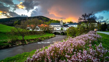 Obraz premium Scenic village by a river at sunset