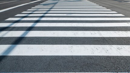 Freshly Painted Zebra Crossing on Urban Street with Clear Sky and Shadows in Bright Daylight