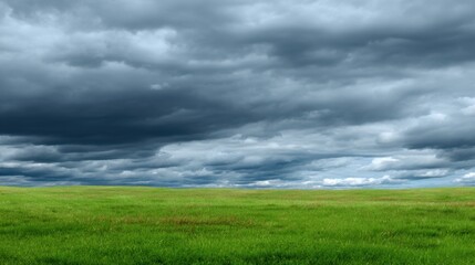 Obraz premium Dramatic Sky Over Expansive Green Field Underneath Heavy Cloud Cover Before Rainstorm