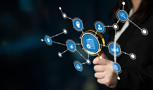 A businesswoman examines social media icons through a magnifying glass, symbolizing digital connectivity and analysis in a modern business environment. Crux - Powered by Adobe